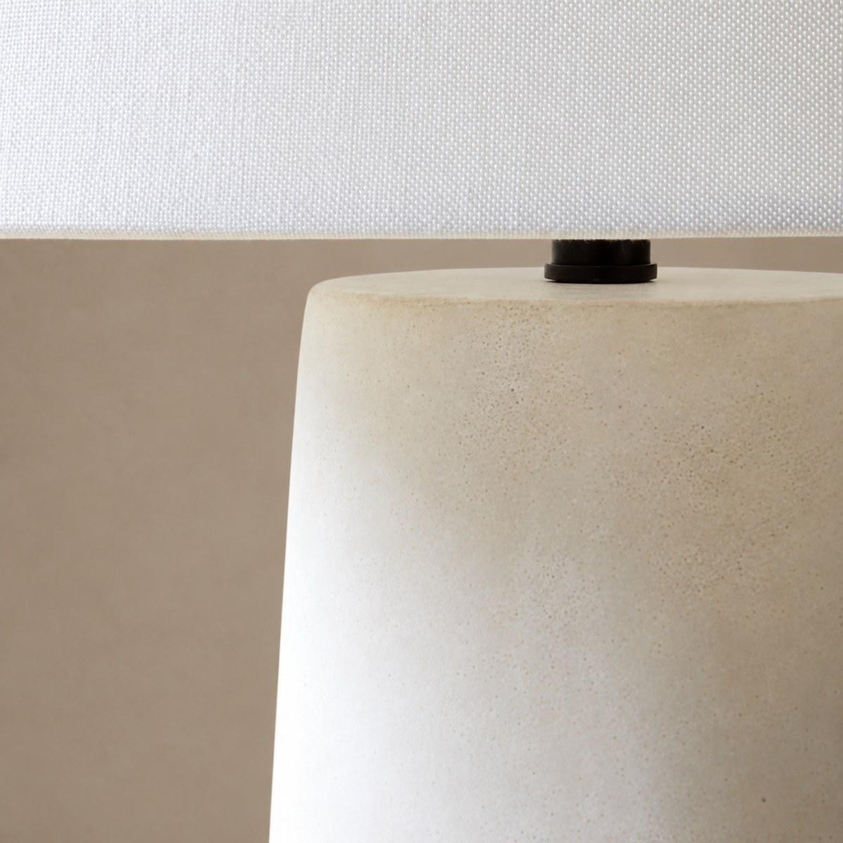Close view of Fungo Bianco's white woven shade, black connector and ivory resin body.