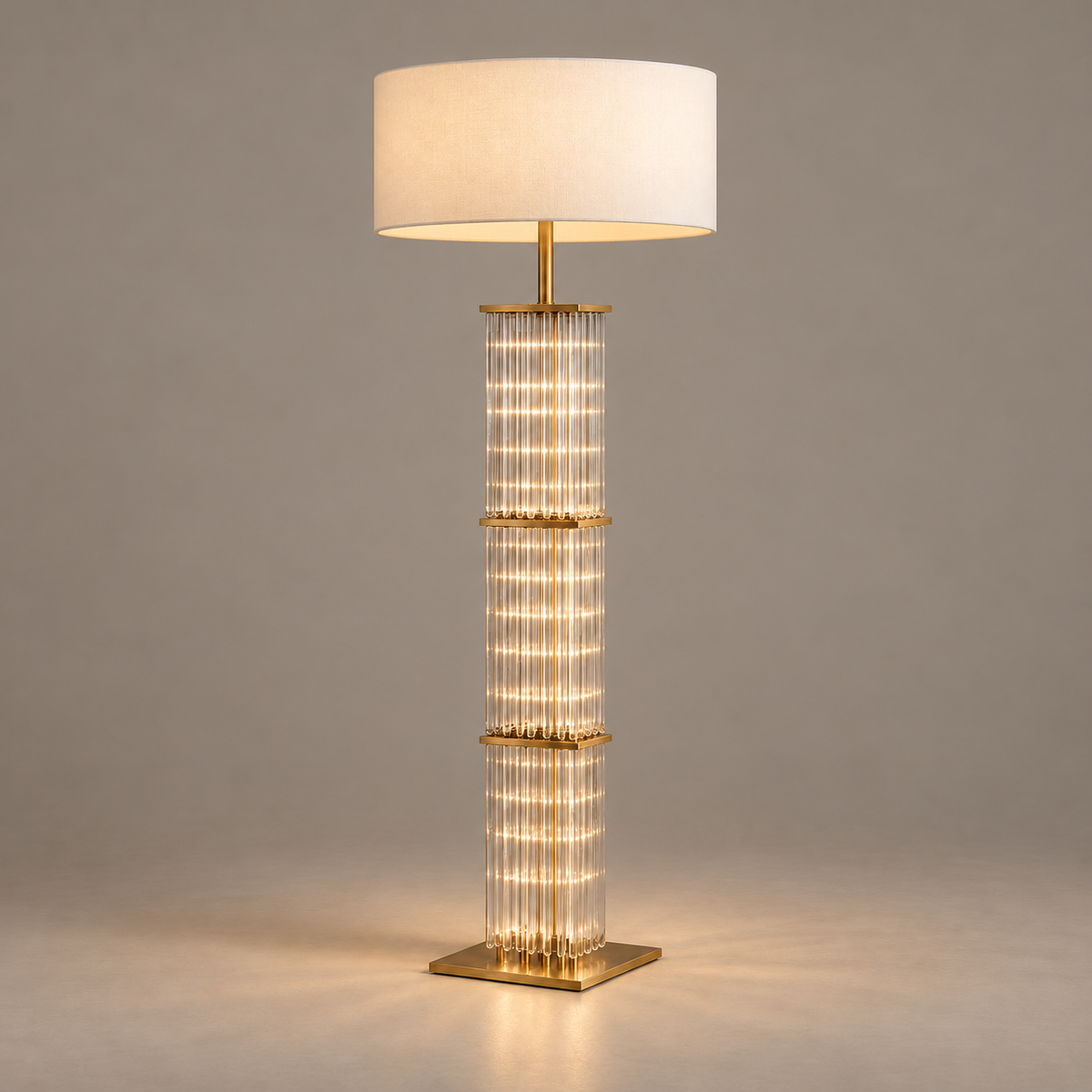 CLGT025 floor lamp with its glass column and white fabric shade illuminated.