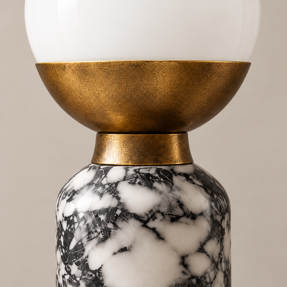 Close view of the grey-and-white marble column, brass collar and opaline glass.
