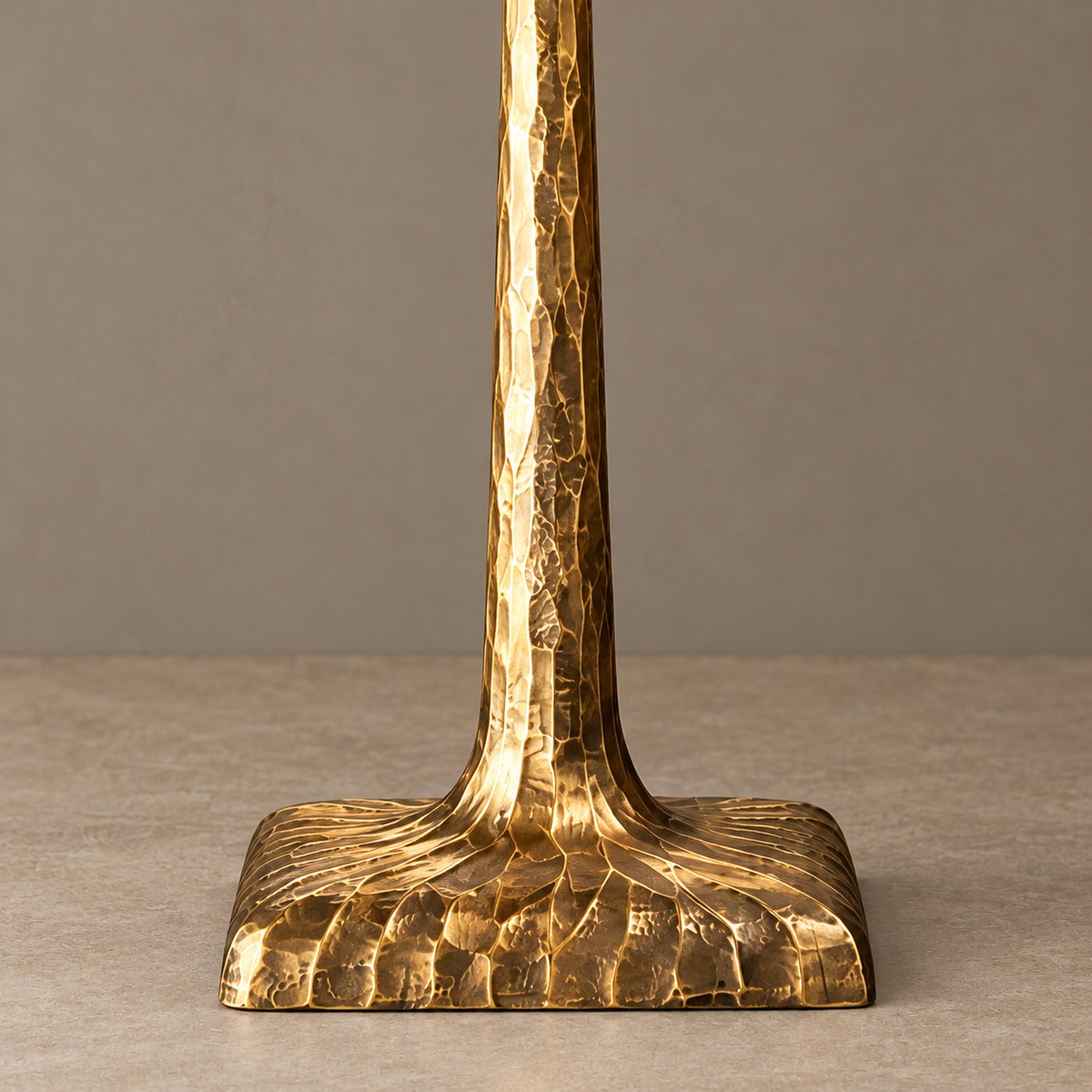 Close-up of the hammered brass stem and flared lamp base.