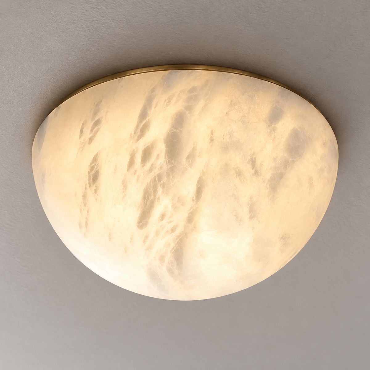 Detail of the honed alabaster dome’s clouded stone and slim brass mounting rim.