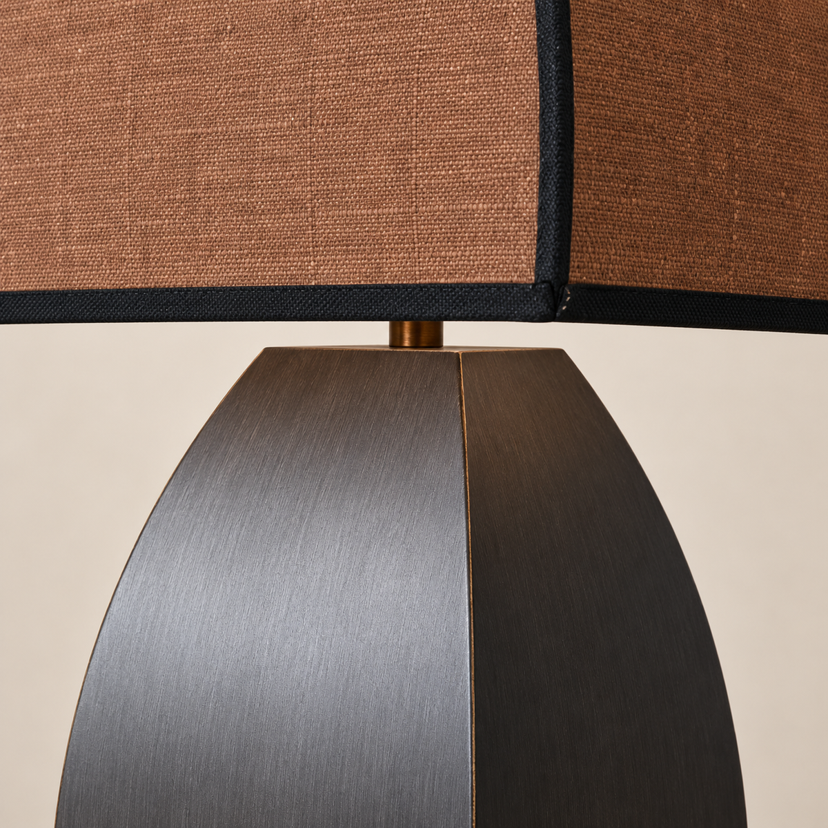 Close view of the faceted iron base and dark fabric shade.
