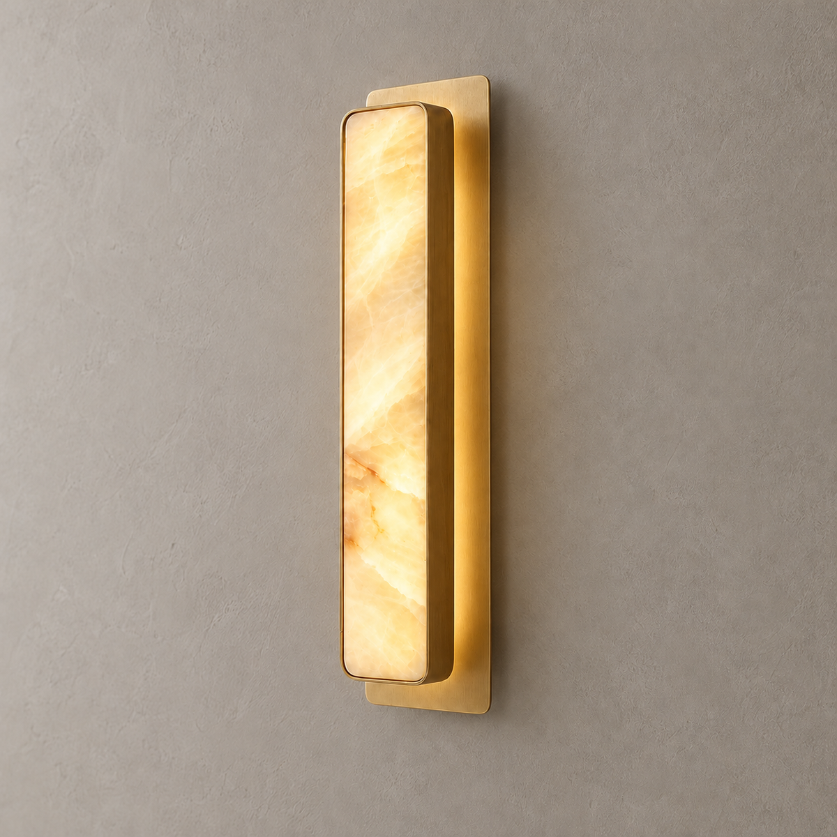 Mont honey onyx wall sconce with projecting brass housing and separate backplate, illuminated.