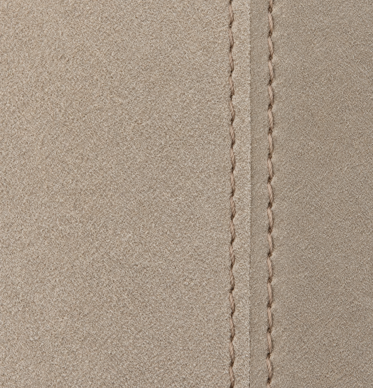 Close view of the fine beige leather texture and double stitched leather seam.