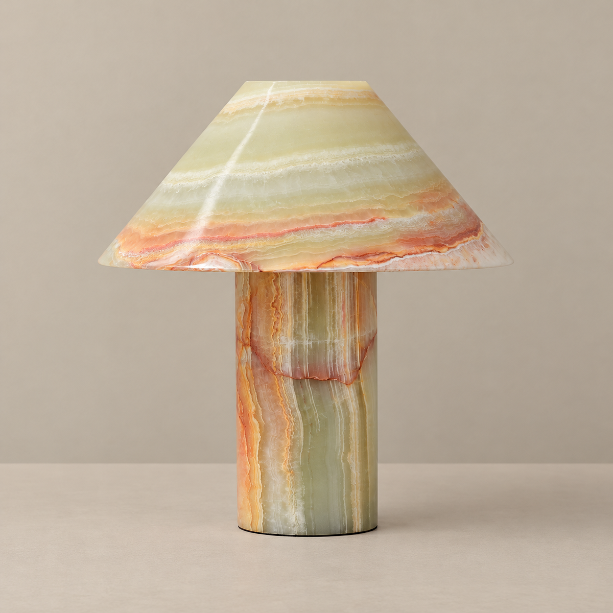 Banded stone table lamp with a conical shade, unlit on a beige background