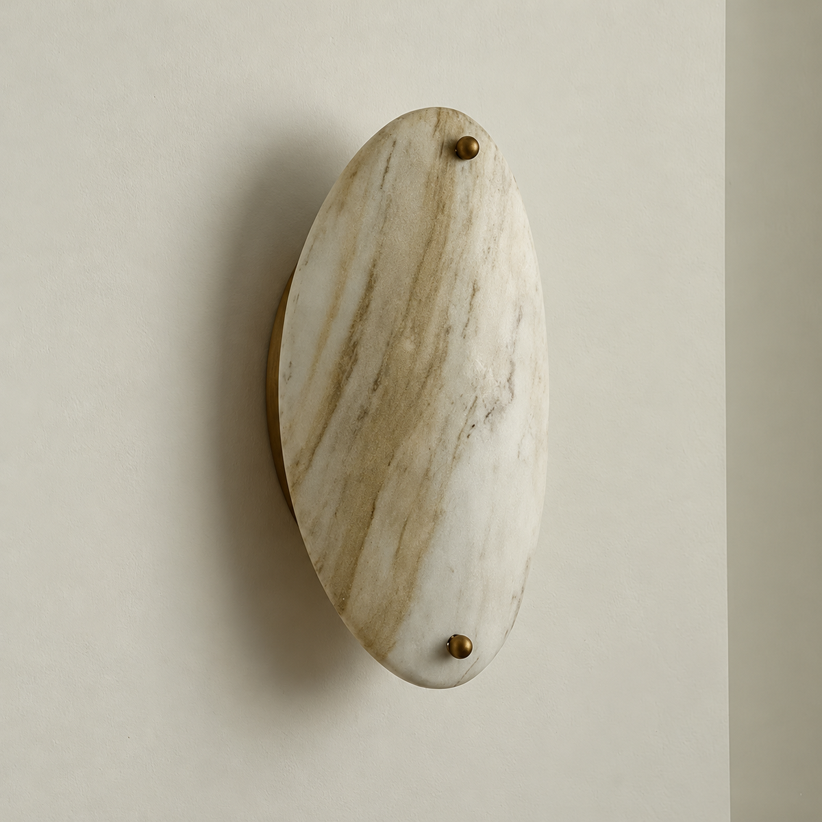 Unlit oval marble wall sconce mounted on warm ivory.