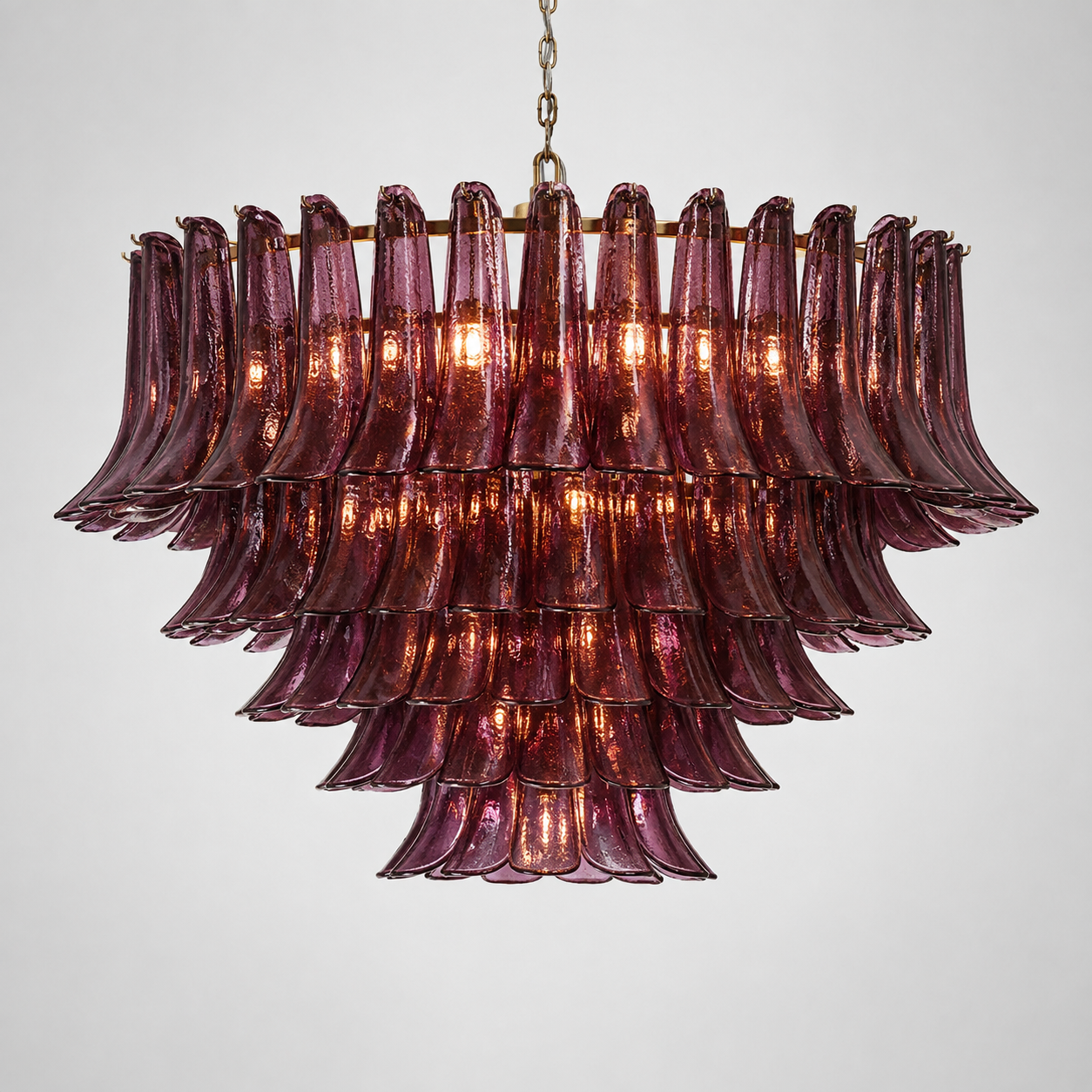Sculptural glass and brass foyer chandelier lit, warm light through the glass forms — CLND006