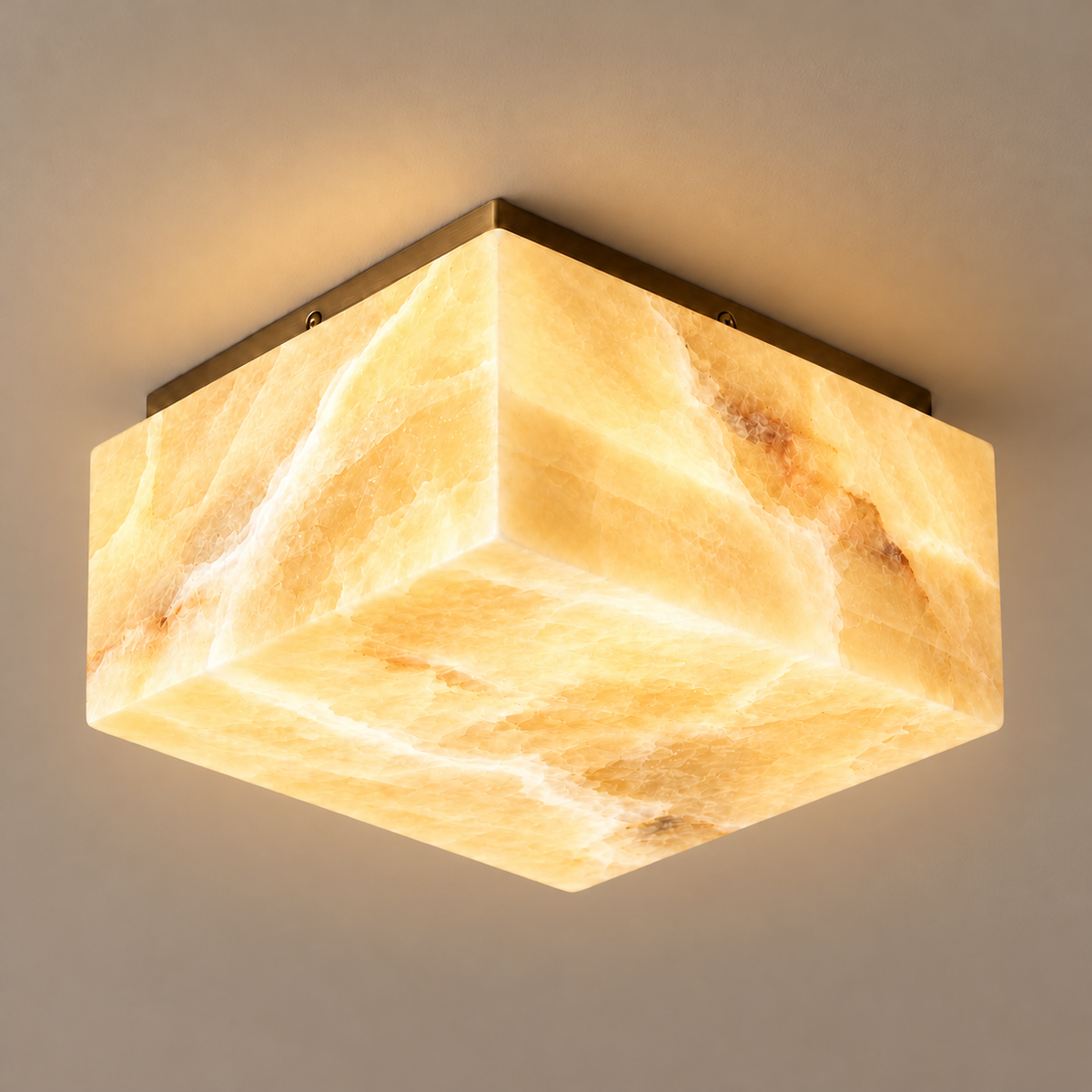 35 cm square honey onyx flush mount with a brass ceiling plate, illuminated.