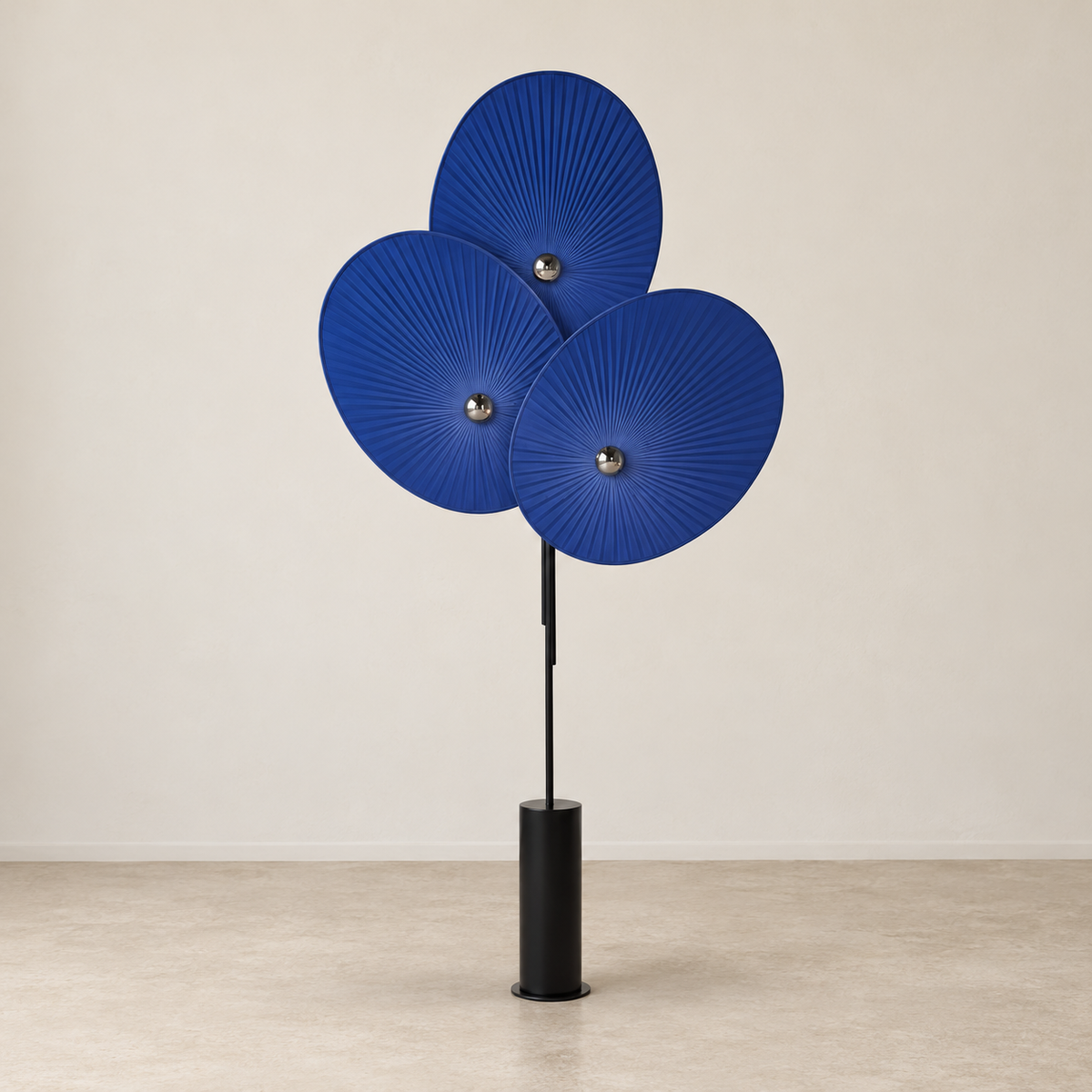 Blue Svelo floor lamp with overlapping pleated shades and a black metal base.