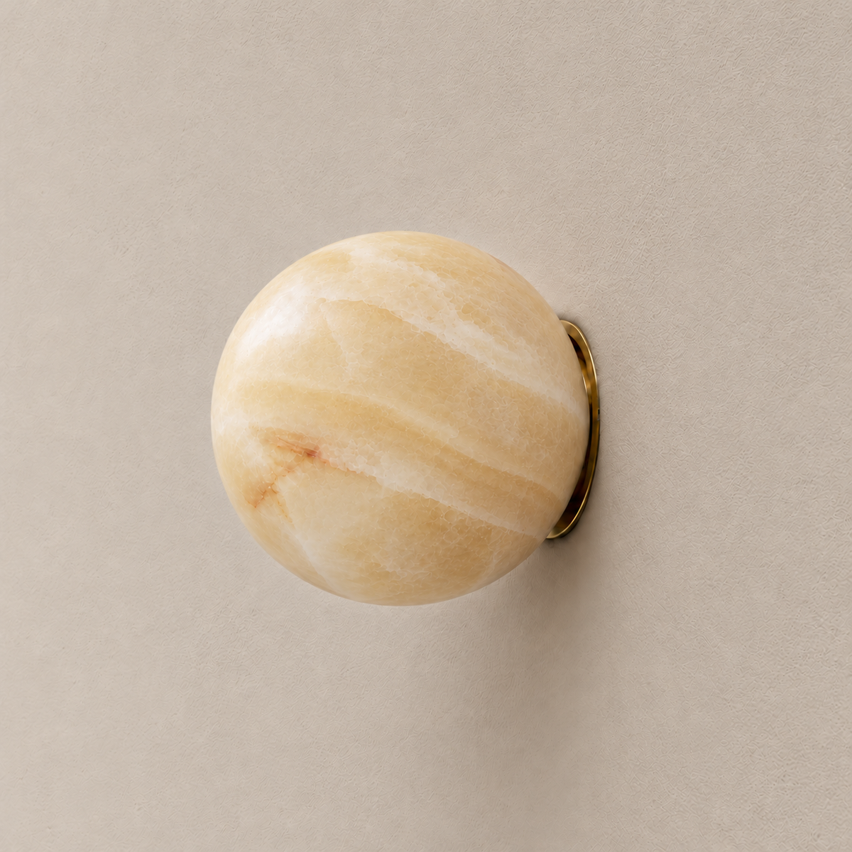 15 cm Totem honey onyx globe wall sconce with brass fitting, switched off.