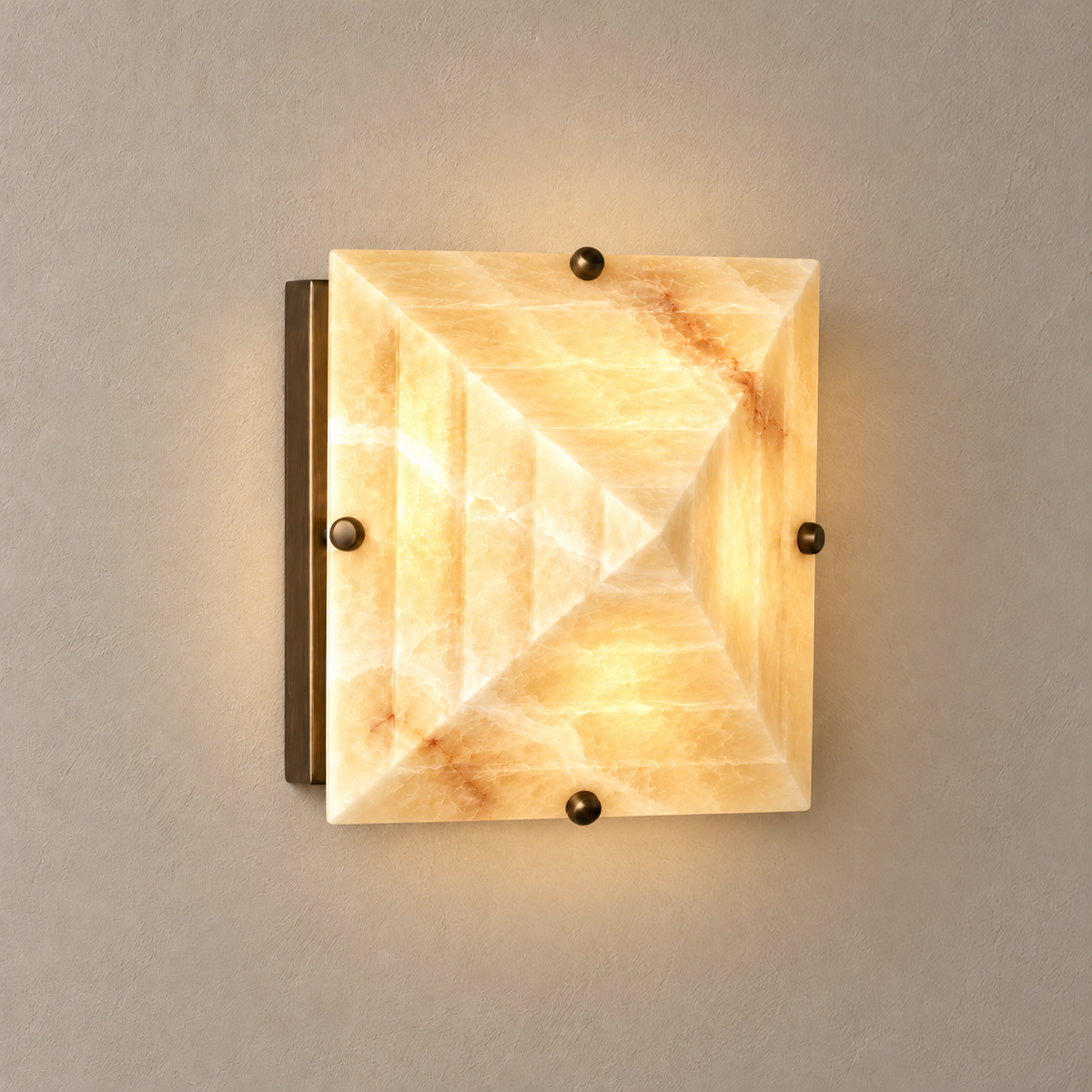 Trapezoidal honey onyx wall sconce with stepped stone planes, illuminated.