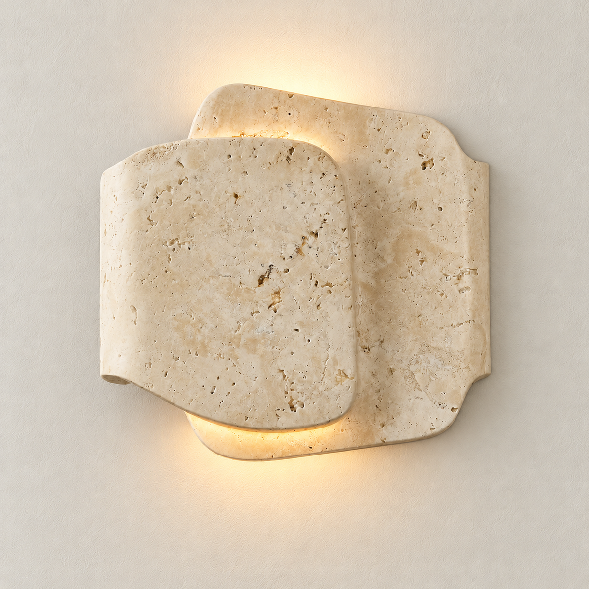 Layered travertine sconce illuminated above and below its curved front panel.