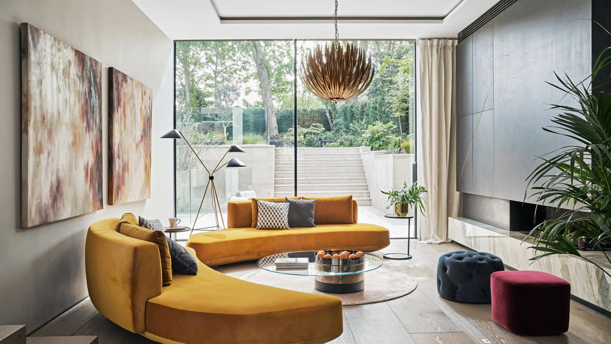 A vibrant mustard-yellow curved velvet sofa with plush cushions and a modern, sleek design.