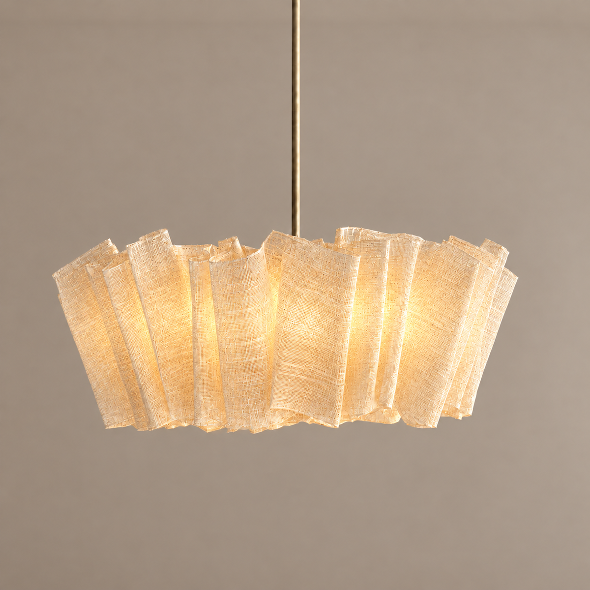 Woven abaca pendant illuminated with warm light passing through the fine open weave.