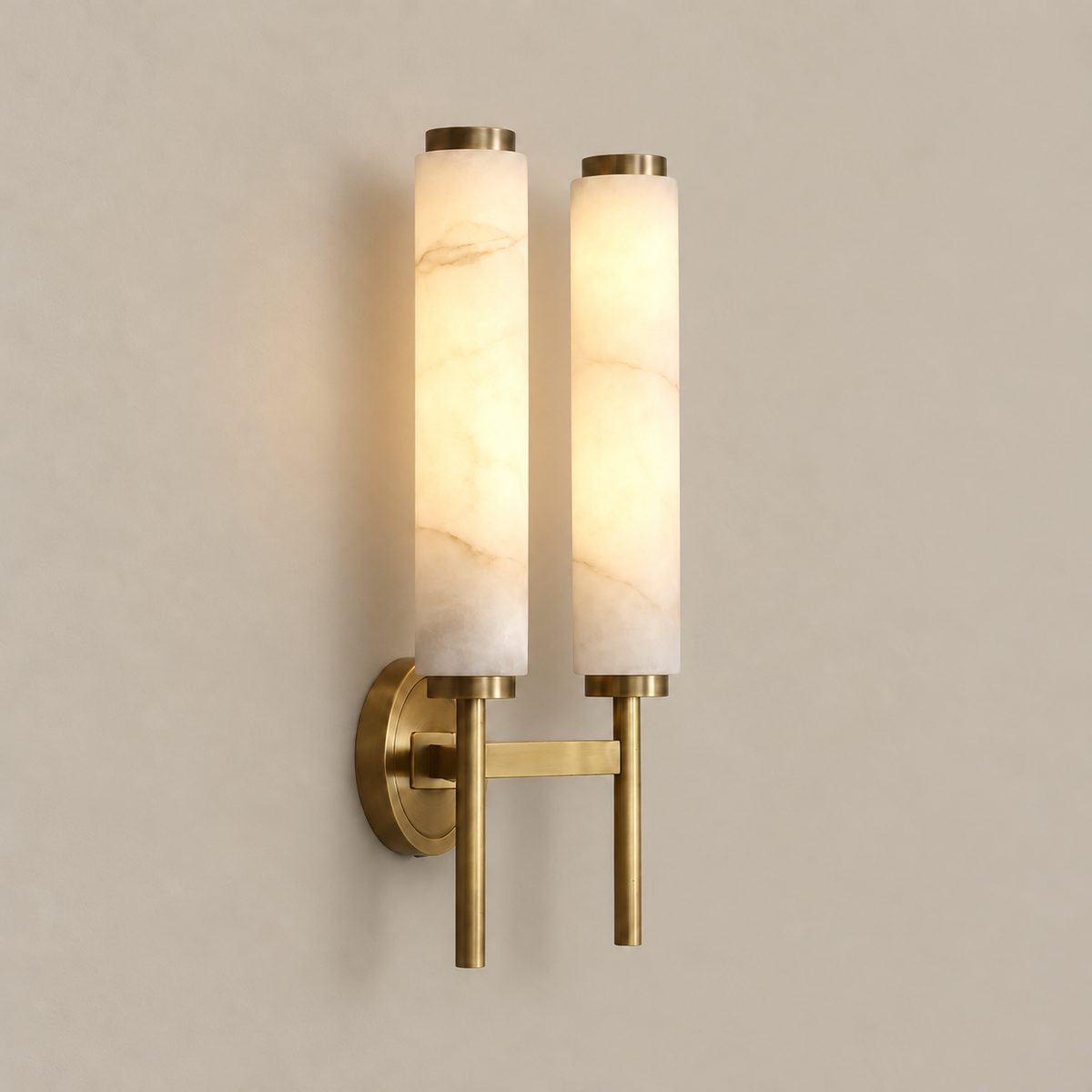 Double alabaster cylinder sconce illuminated through its natural stone.