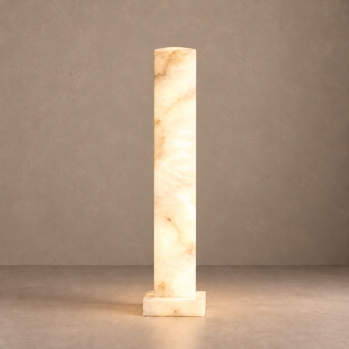 Medium alabaster column lamp glowing softly through its mineral layers.