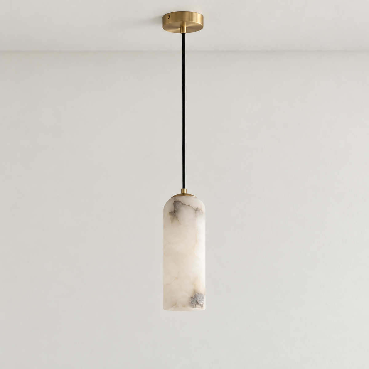 Alabaster column pendant with brass cap and black cord, unlit.