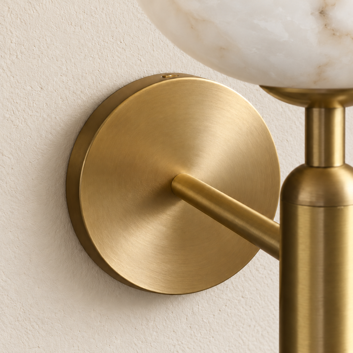 Close detail of alabaster tulip wall sconce with a brass stem and its mounting hardware.
