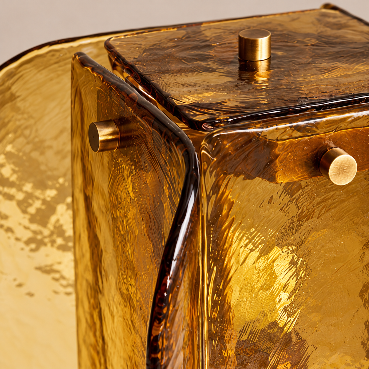 Detail of textured amber glass panels and brass-tone fasteners