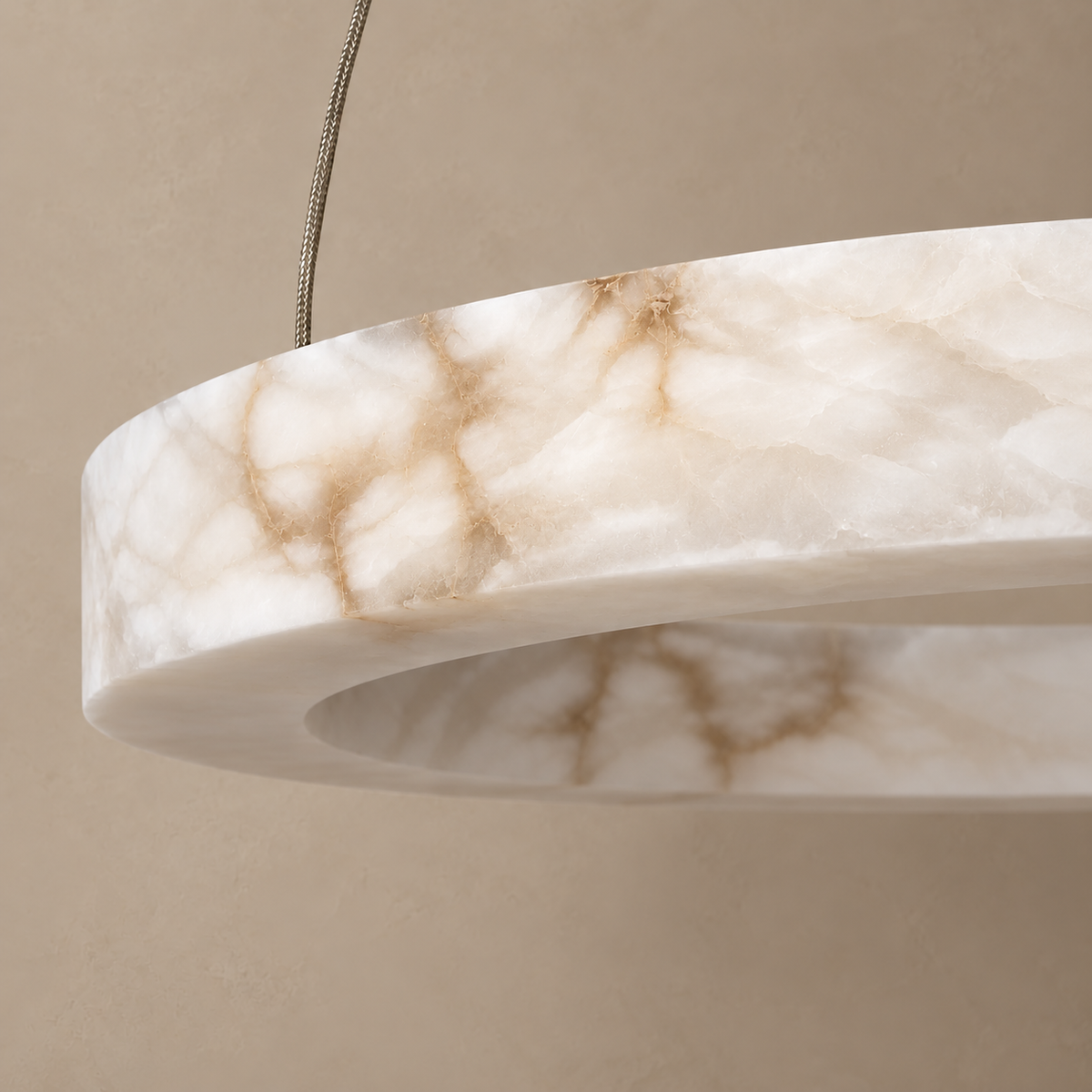 Close-up of natural cloudy alabaster and a suspension cable on Anelli Tre Large.