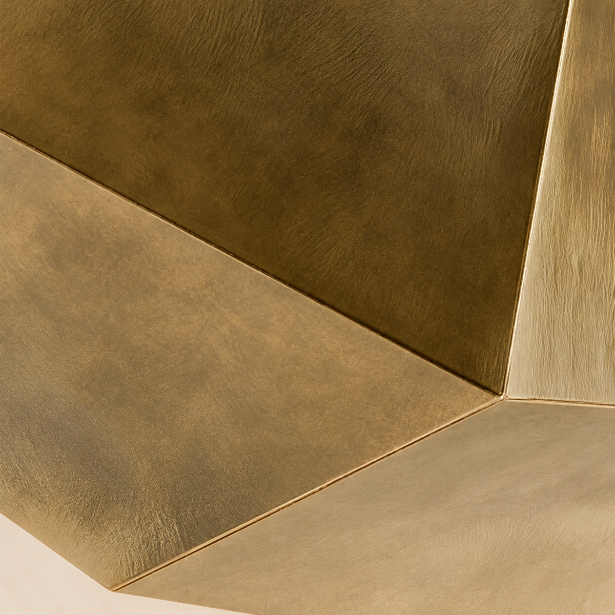 Close view of the Aventine shade's folded planes and mottled Antique Gold patina.
