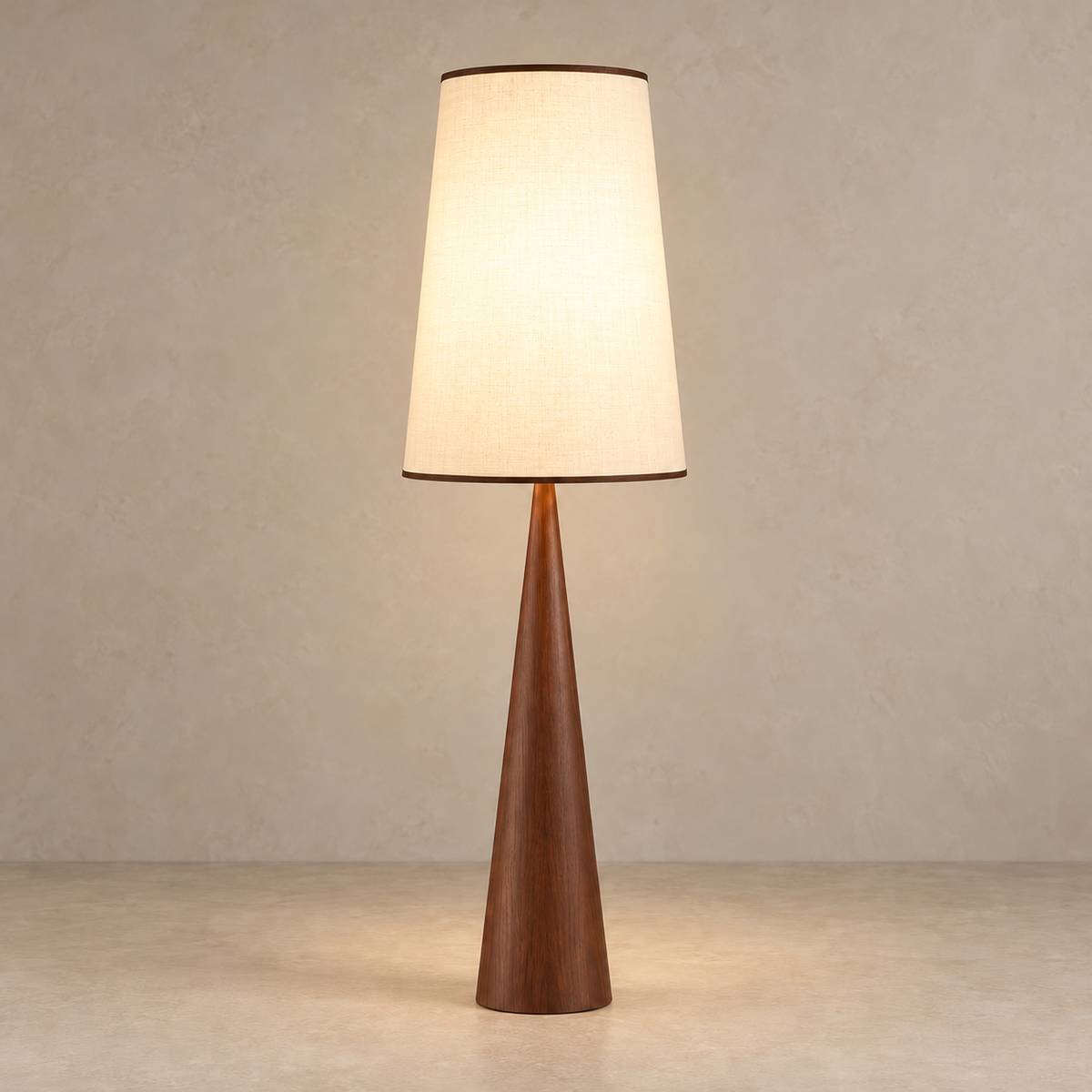 Walnut CLBAK floor lamp illuminated through its cream fabric shade.
