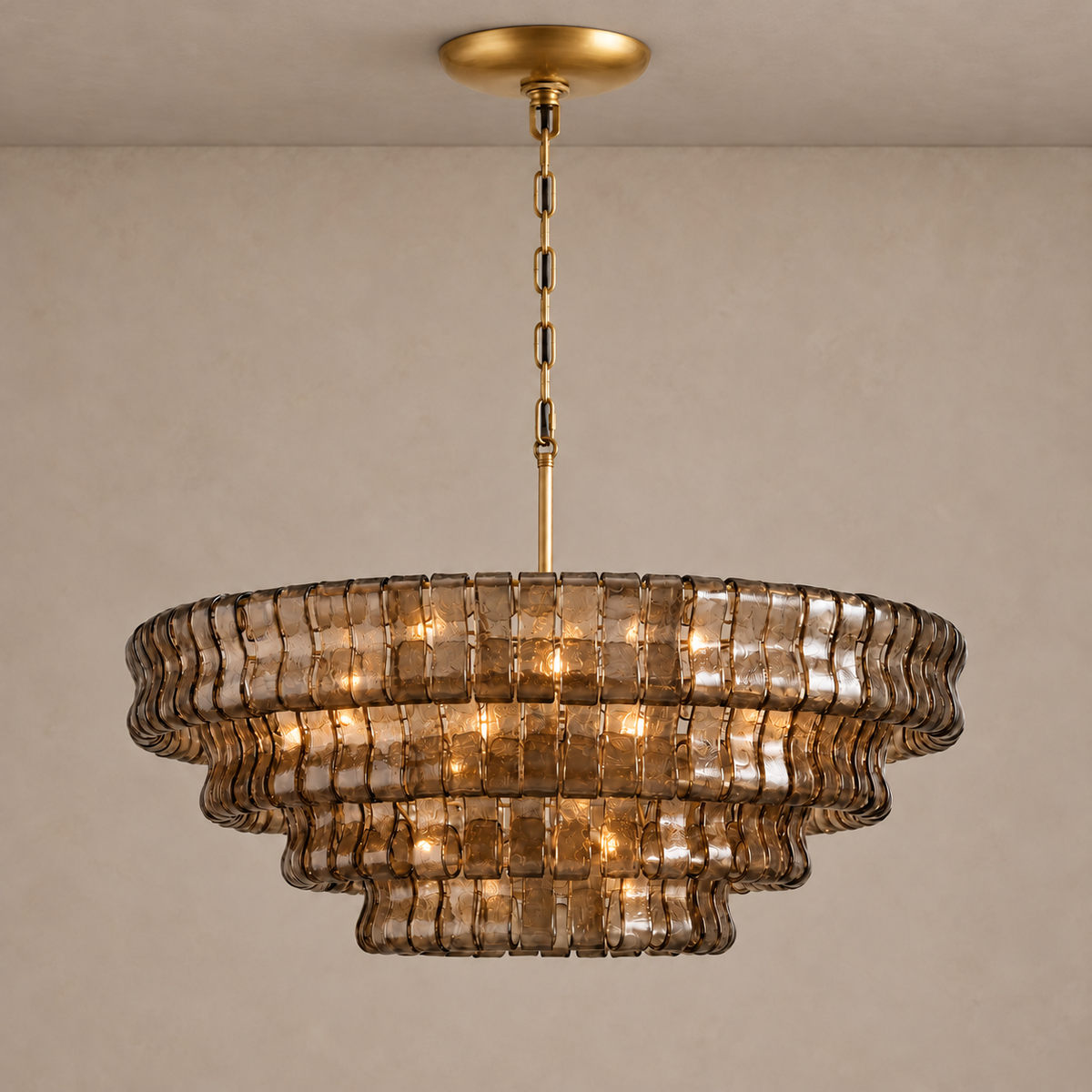 Round Bellatrix chandelier illuminated behind its tiers of smoky brown curved glass.