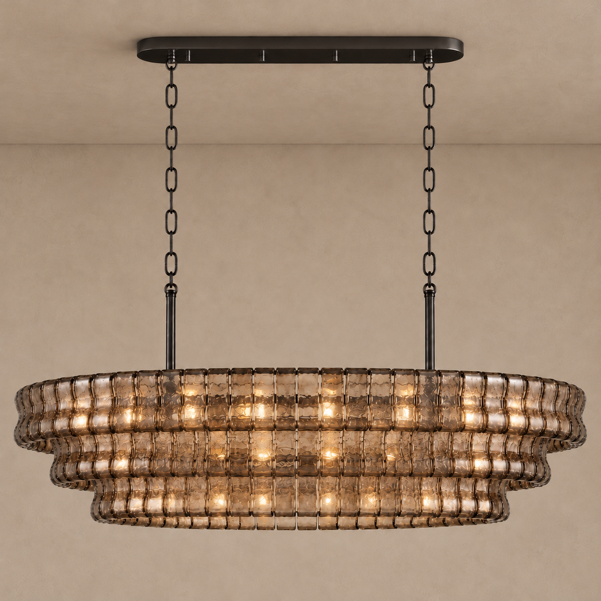 Bellatrix Long chandelier illuminated through its smoky brown curved glass panels.