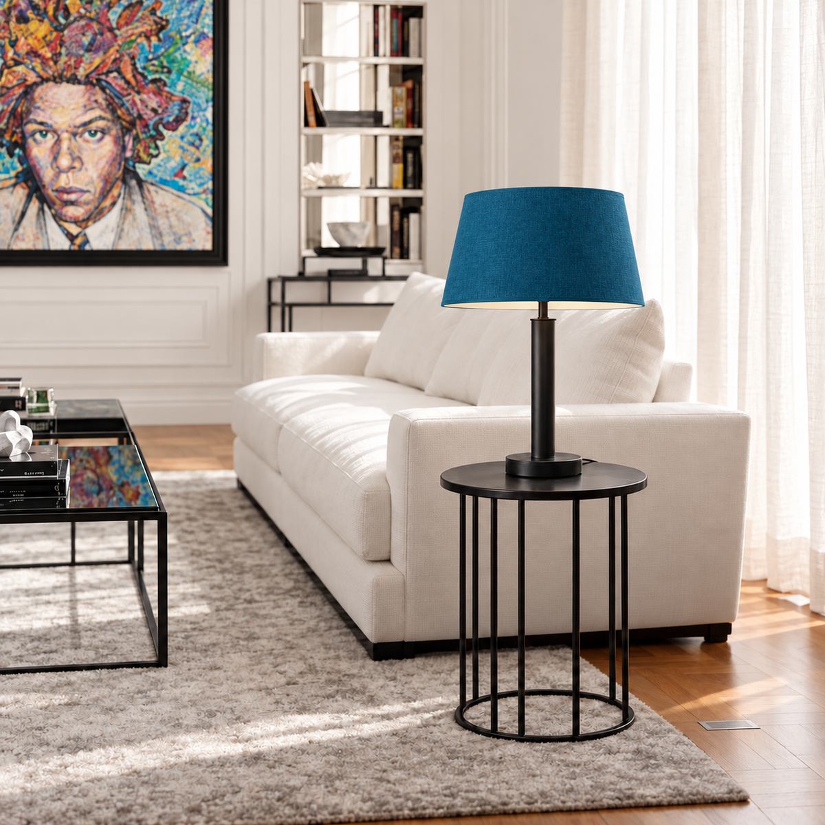 Matte black stainless steel table lamp with a petrol blue tapered fabric shade on a side table beside a cream sofa.
