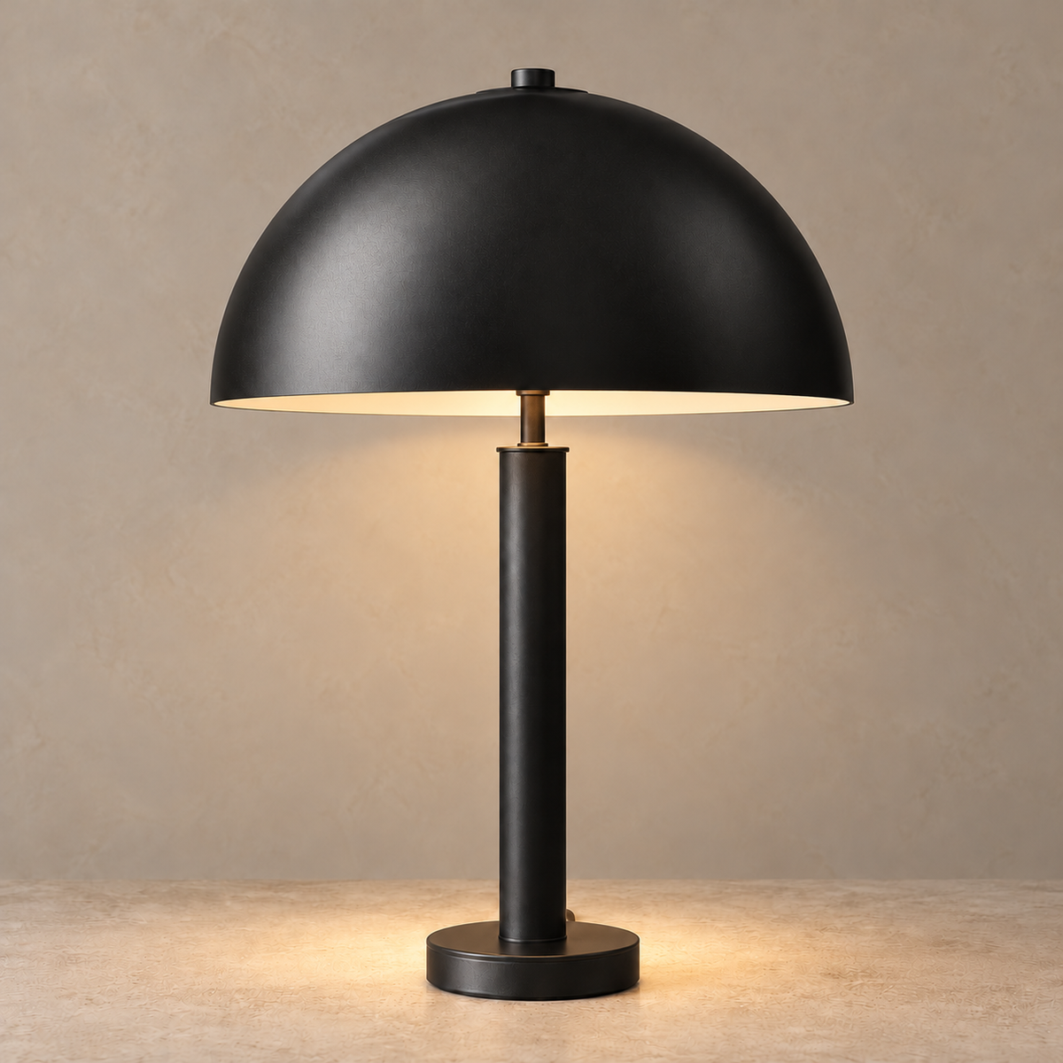 Black dome table lamp casting a warm pool of light onto a beige tabletop.