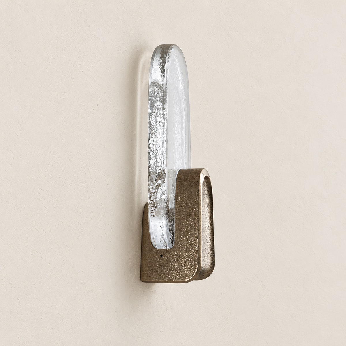 Side view of the brass wall sconce showing thick bubbled glass and its textured brass cradle.