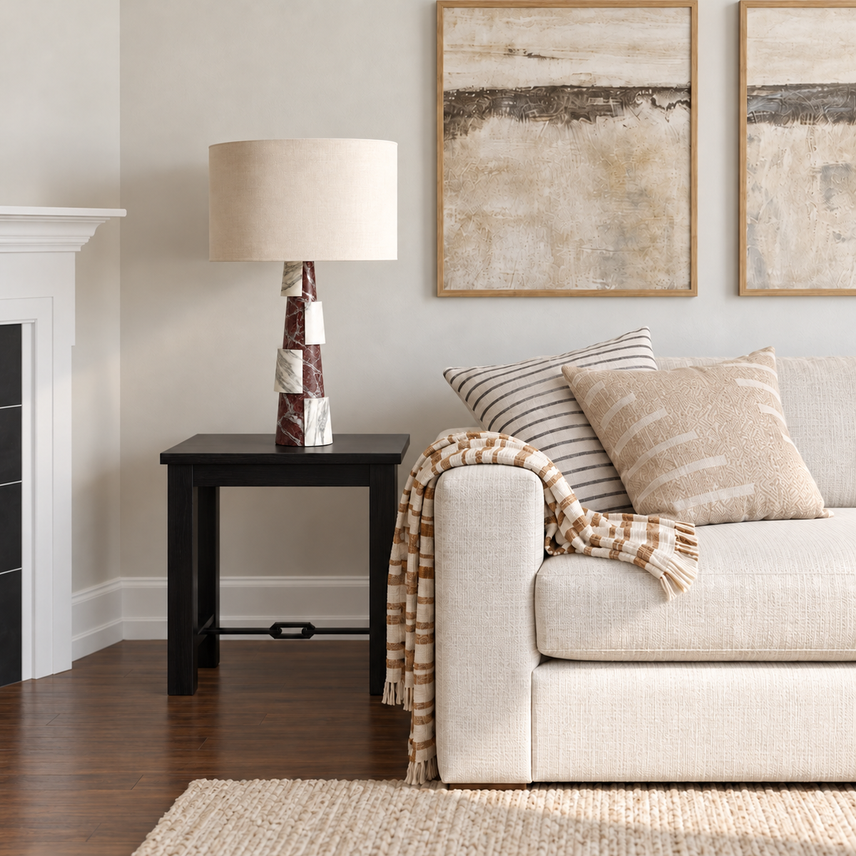 Burgundy and white marble table lamp with a natural linen drum shade on a side table beside a cream sofa.