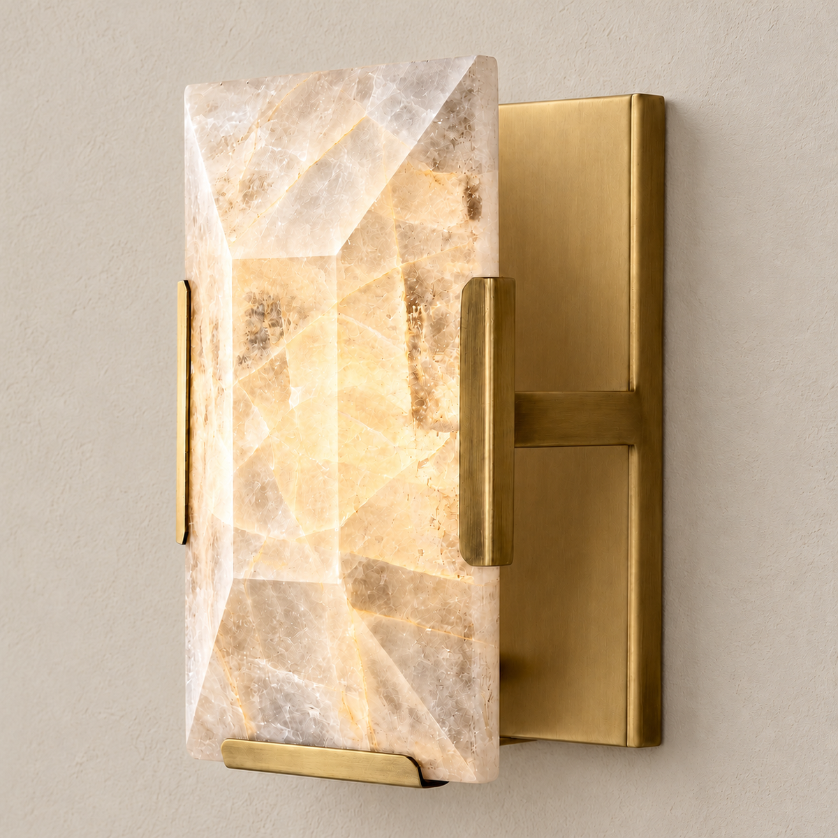 Calcite wall sconce with brass hardware, illuminated through the natural stone.