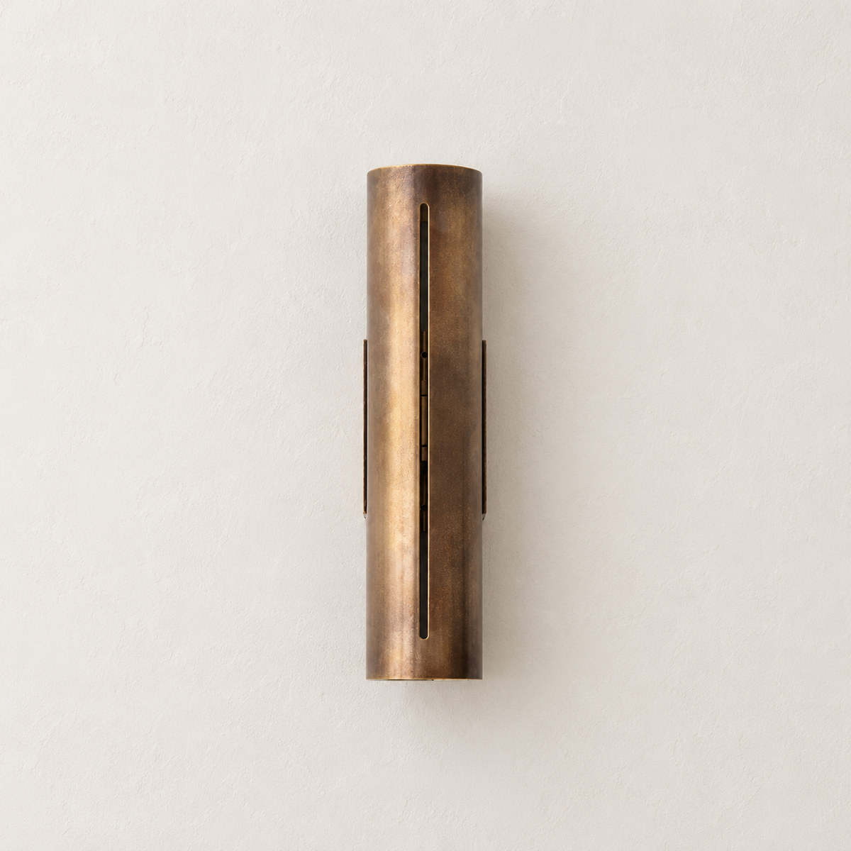 Unlit 35 cm copper cylinder wall light with a narrow vertical slit on warm ivory.