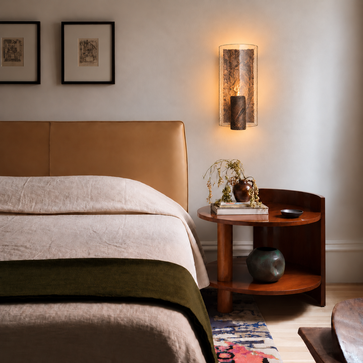 Copper-finish glass and cast-steel wall sconce mounted flat on the wall above a walnut bedside table.