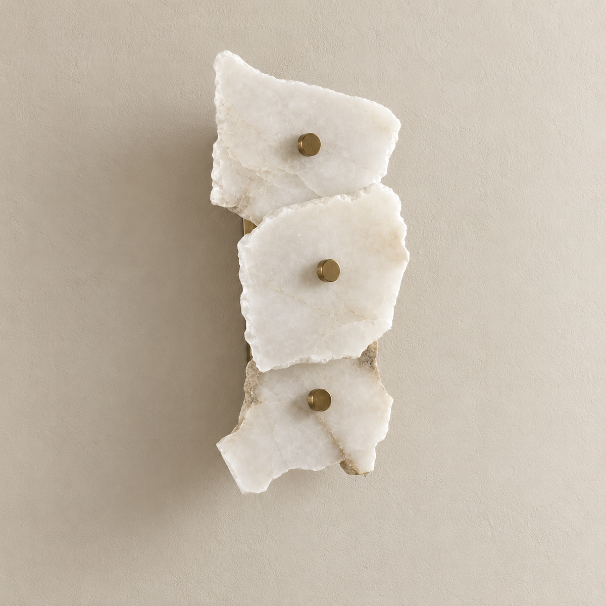 Unlit 3-stone marble wall sconce with irregular layered panels and brass retaining caps.