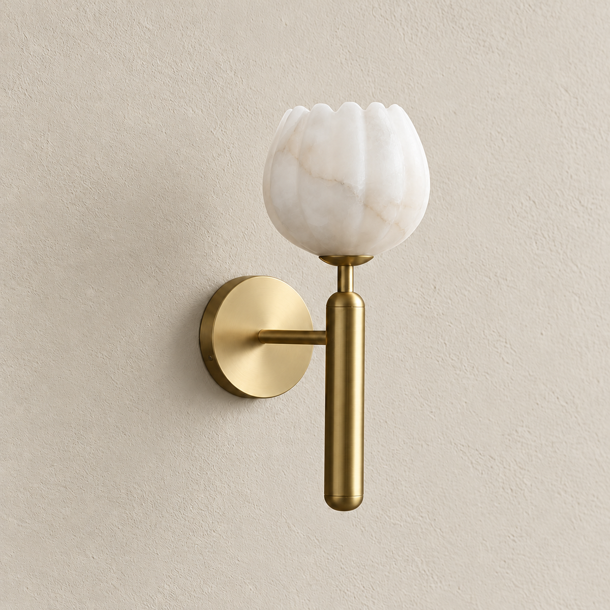 Alabaster tulip wall sconce with a brass stem unlit on warm ivory plaster.