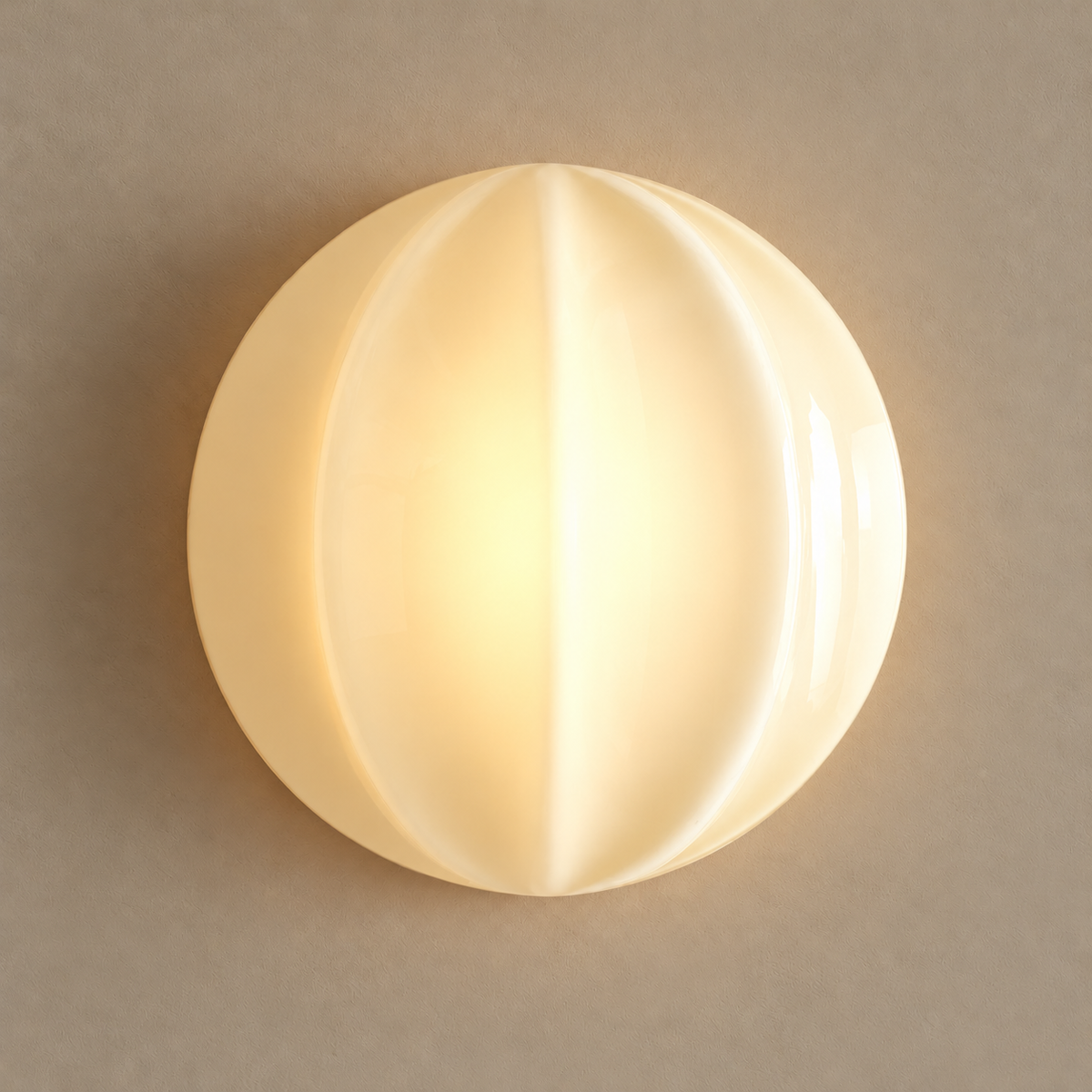Fede ribbed cream glass and brass wall sconce, illuminated on a stone-beige wall