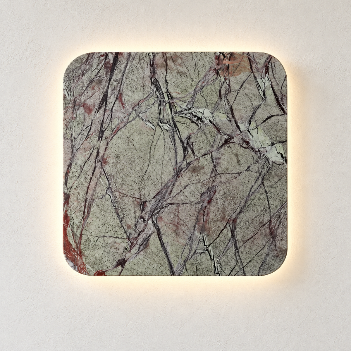 Square green marble wall light with dark natural veining, illuminated on ivory plaster.