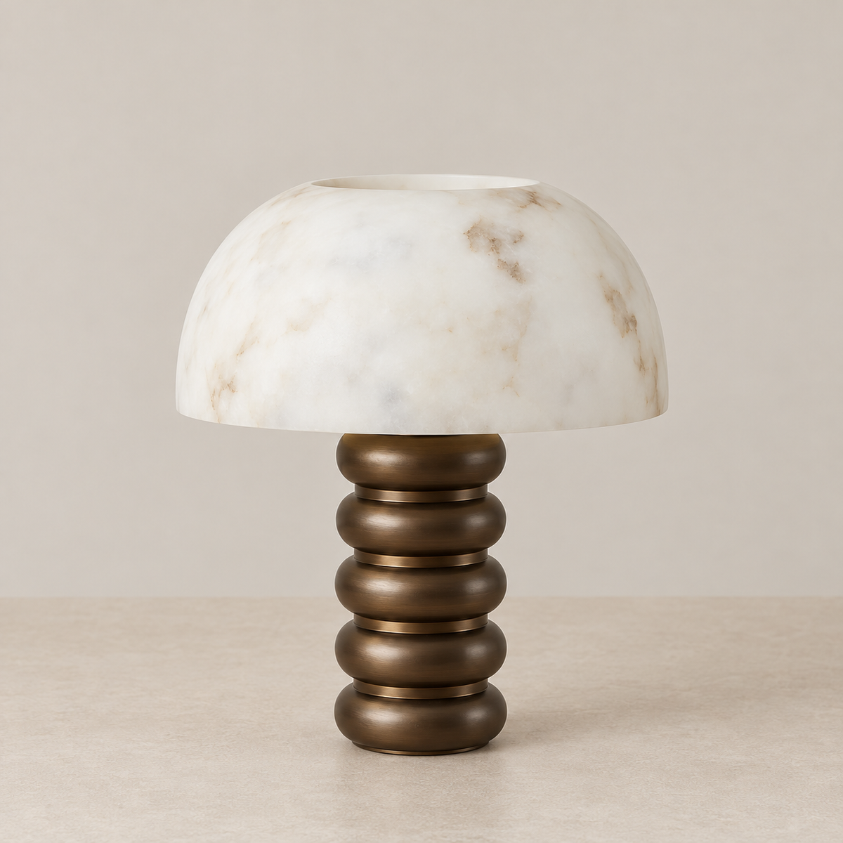 Alabaster dome table lamp with tiered bronze base, switched off on a beige background.