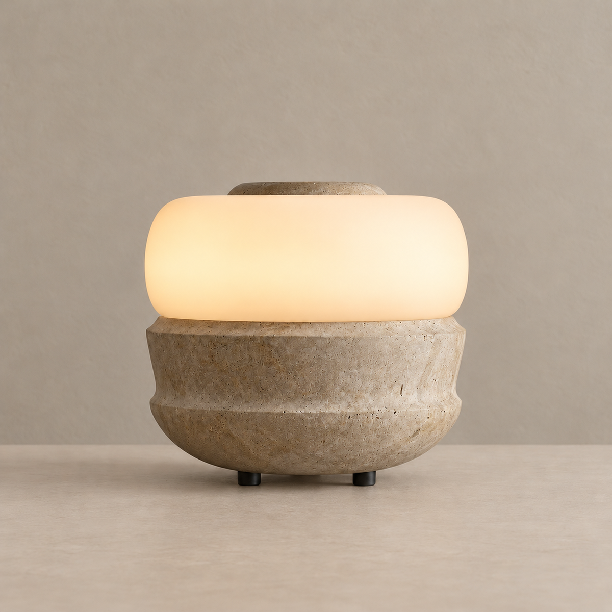 Compact stone table lamp with a frosted glass band, illuminated on a beige background
