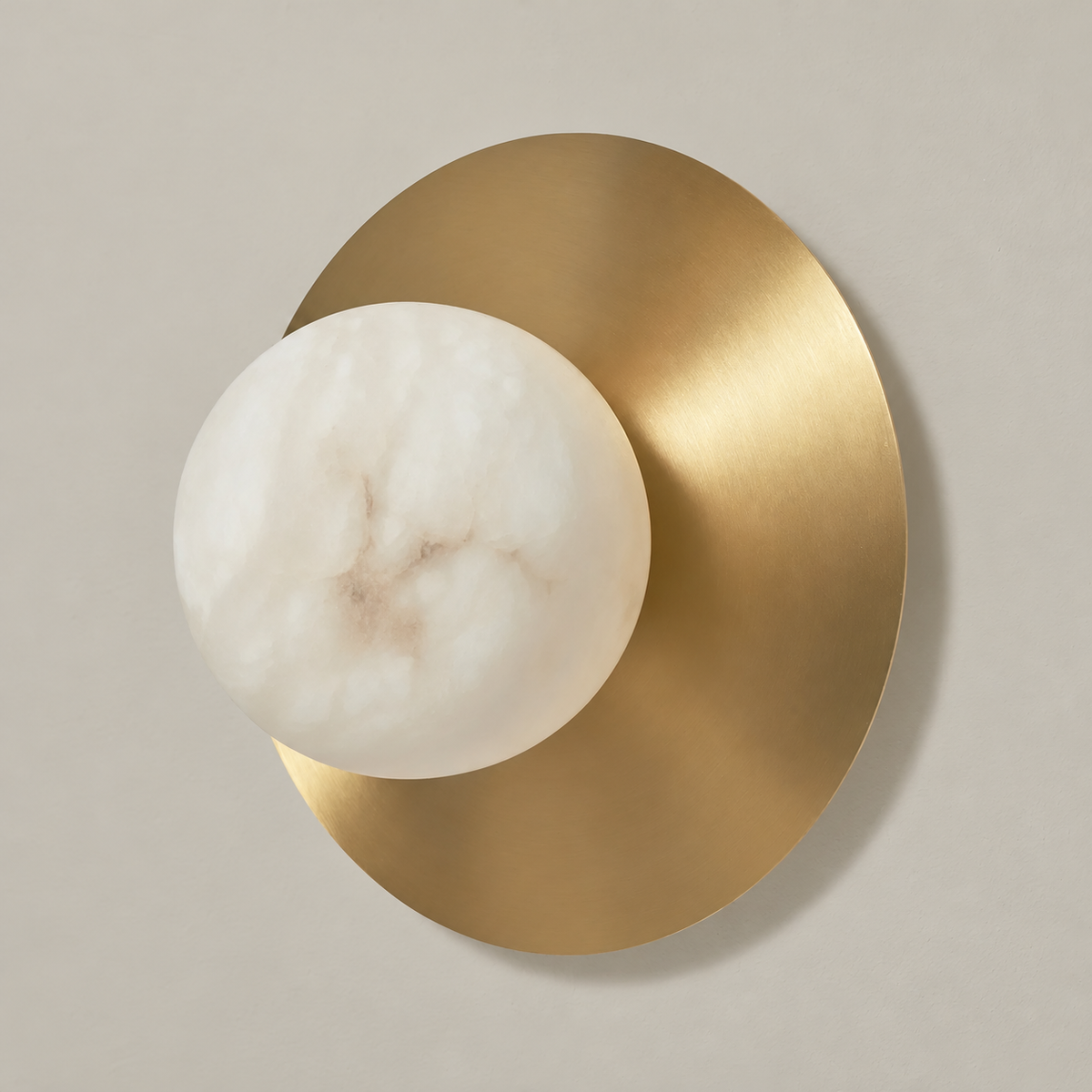 Alabaster globe and brass disc wall sconce, switched off.