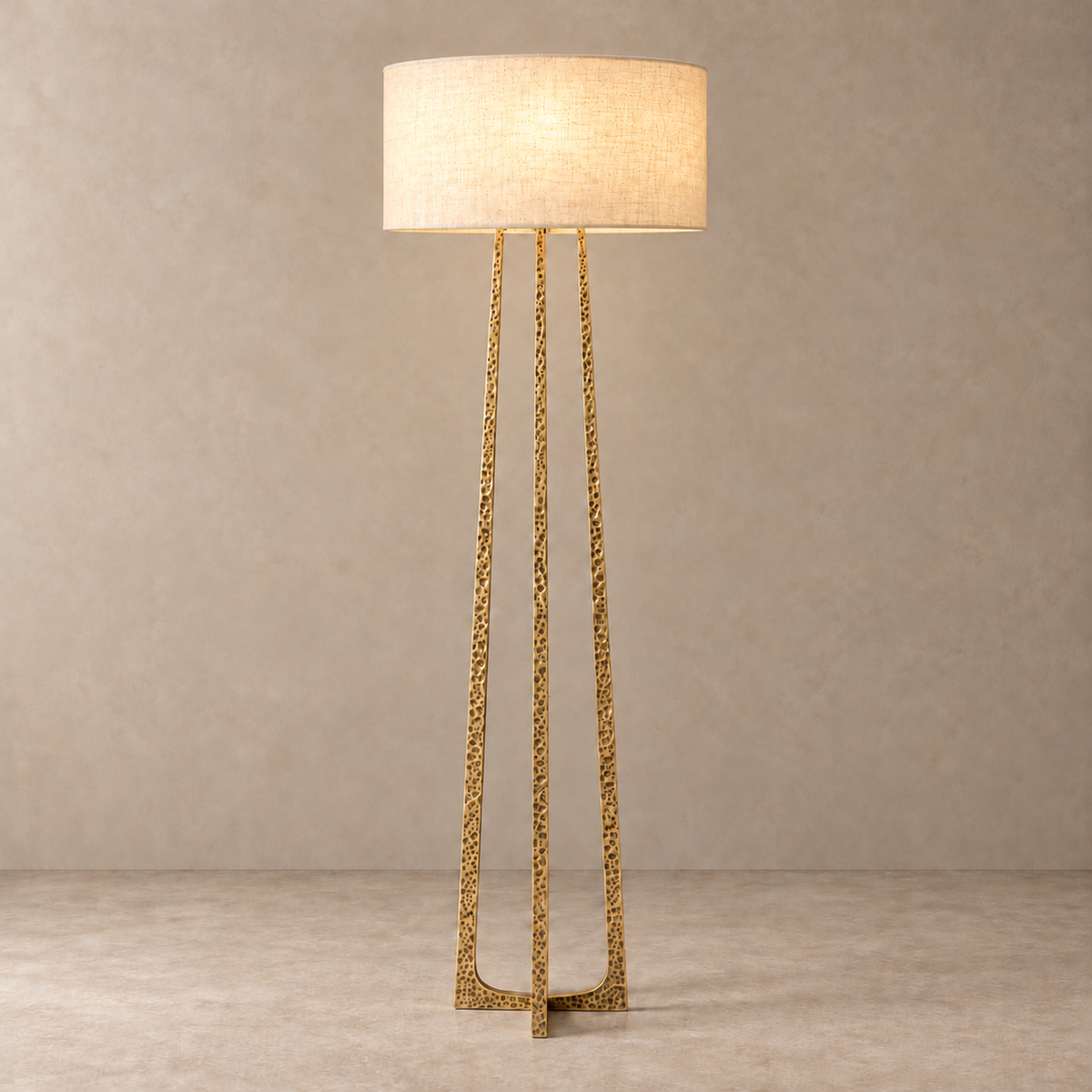 CLHJRH054 floor lamp with its linen drum shade illuminated above the gold crossed frame.