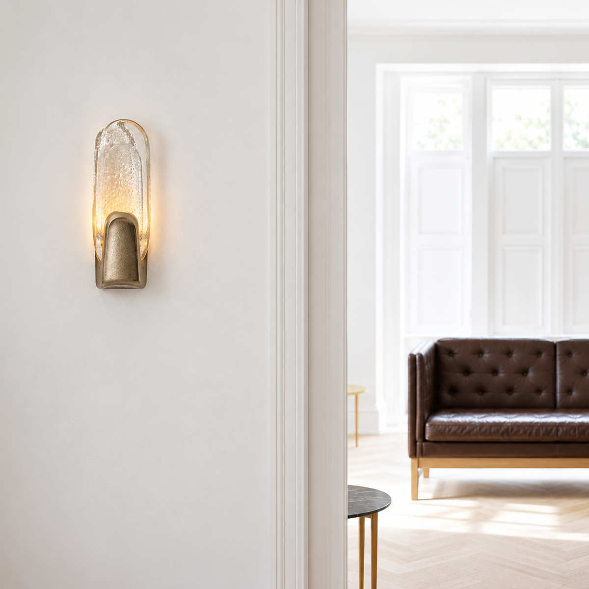 Brass and bubbled glass wall sconce beside a doorway overlooking a leather bench.