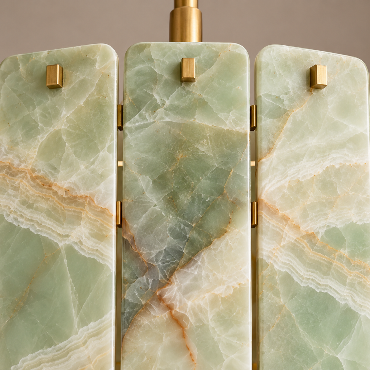 Close view of green onyx panels, rounded stone edges and brass studs on Matra Corona.