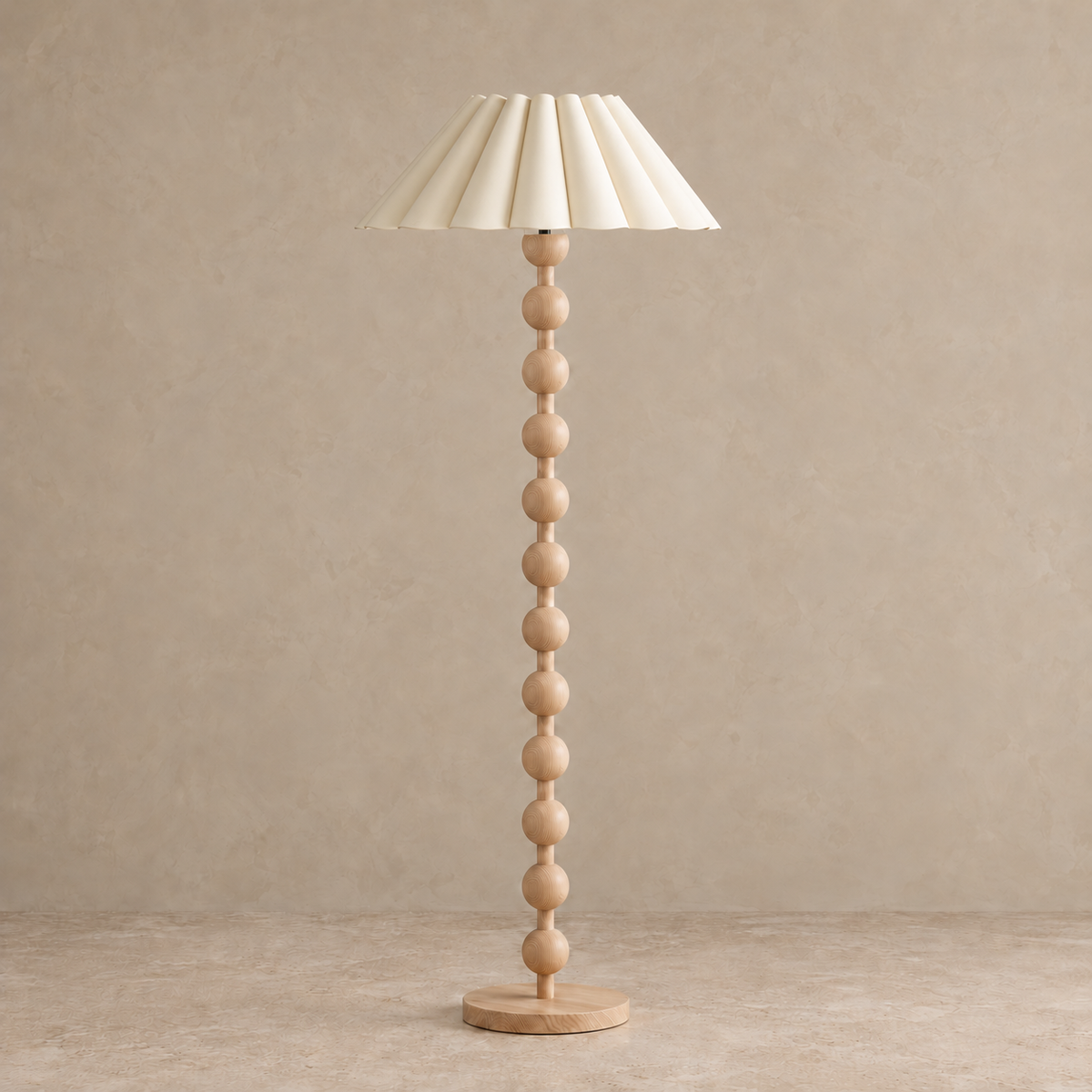 Sirmione Natural Wood Floor Lamp with cream sculptural pleated shade, unlit against a stone-beige background.