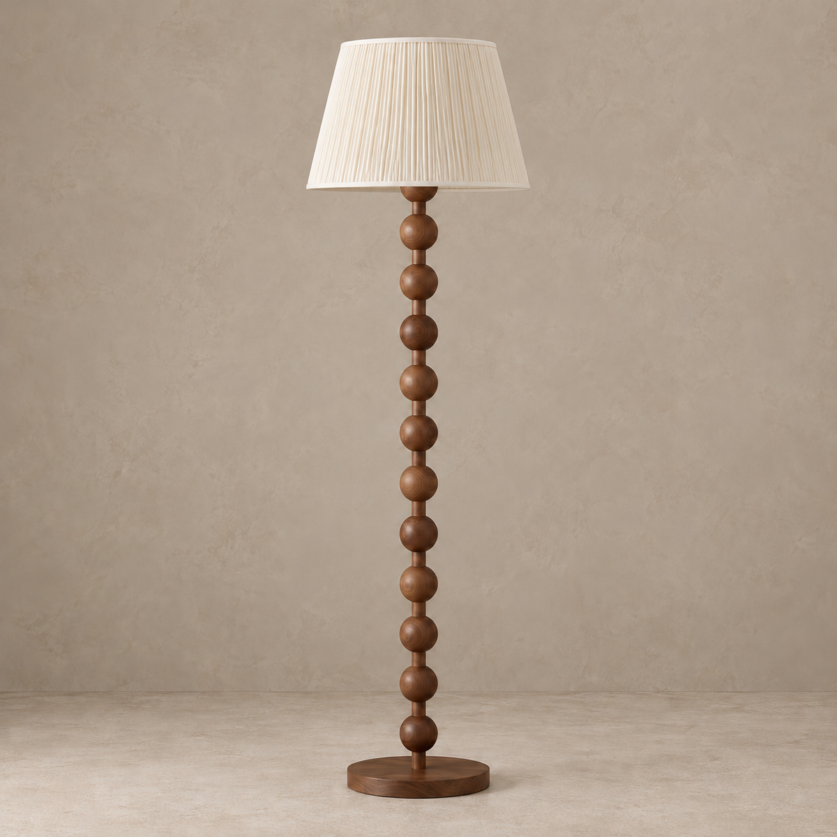 Sirmione Walnut Floor Lamp with cream fine pleated shade, unlit against a stone-beige background.