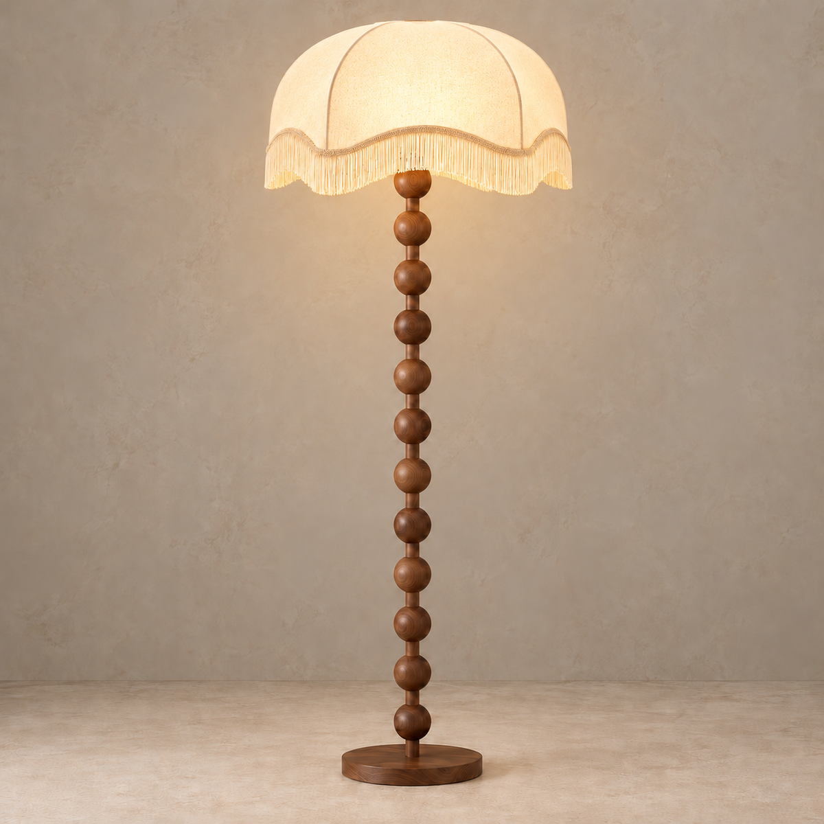 Sirmione walnut floor lamp with its broad cream scalloped fringe shade illuminated.