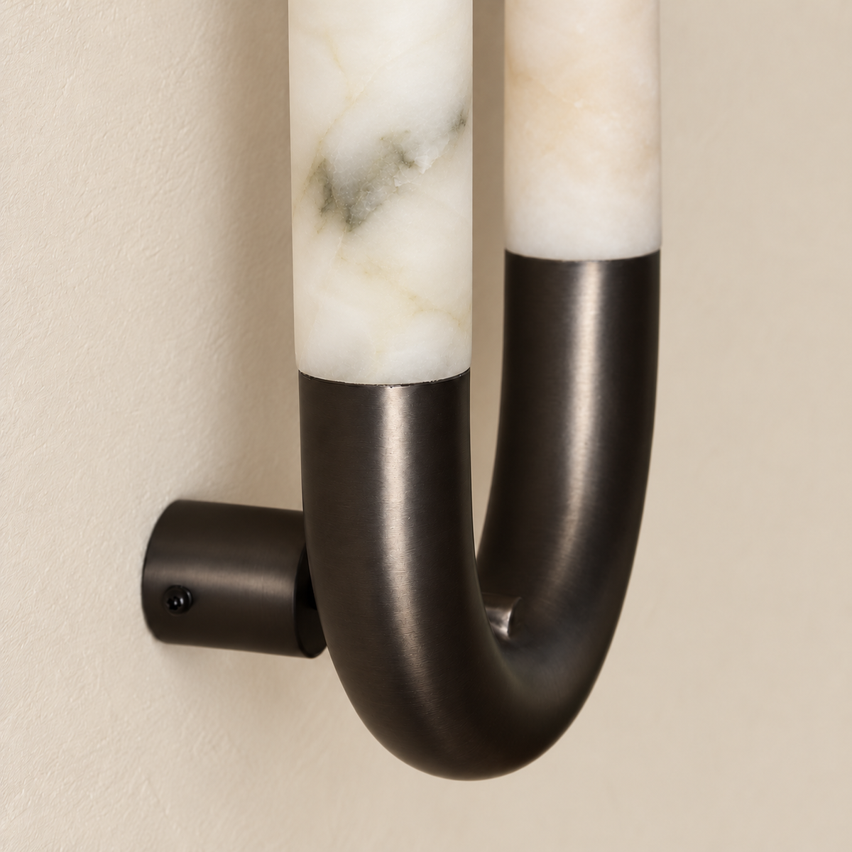 Close-up of the alabaster oval sconce’s black curved connector and circular wall mount.