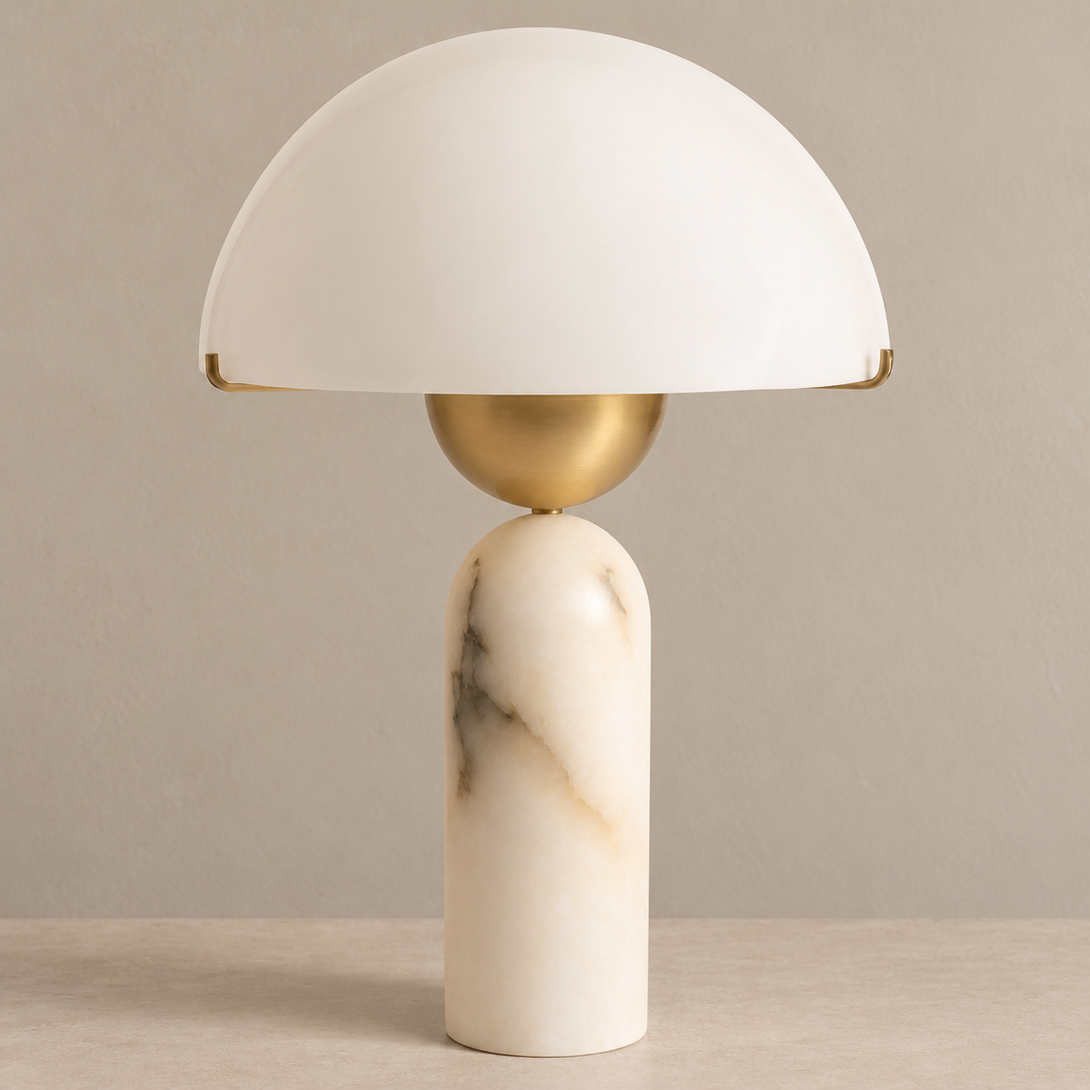 White dome table lamp with a marble column and brass bowl, unlit on a beige background